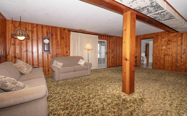 carpeted living area with beam ceiling and wooden walls