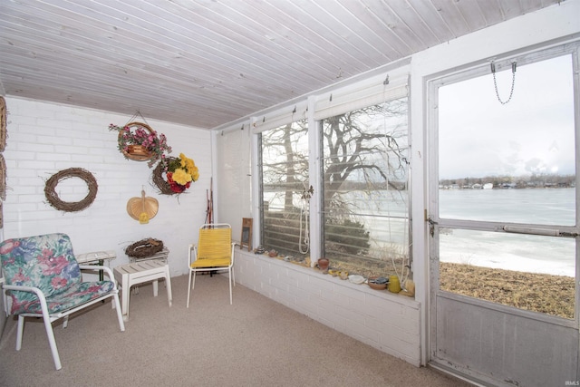 sunroom featuring wood ceiling and a water view