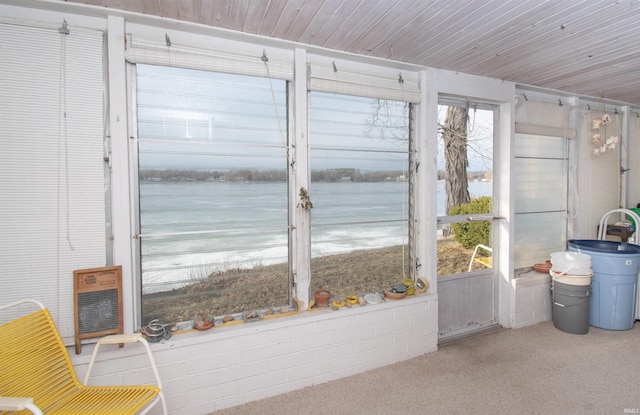 unfurnished sunroom featuring a water view and wood ceiling