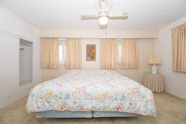 bedroom with ceiling fan, carpet floors, and wallpapered walls