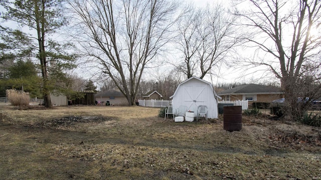 view of yard with an outbuilding, fence, and a storage unit