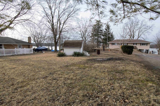 view of yard with an outdoor structure, fence, and a shed