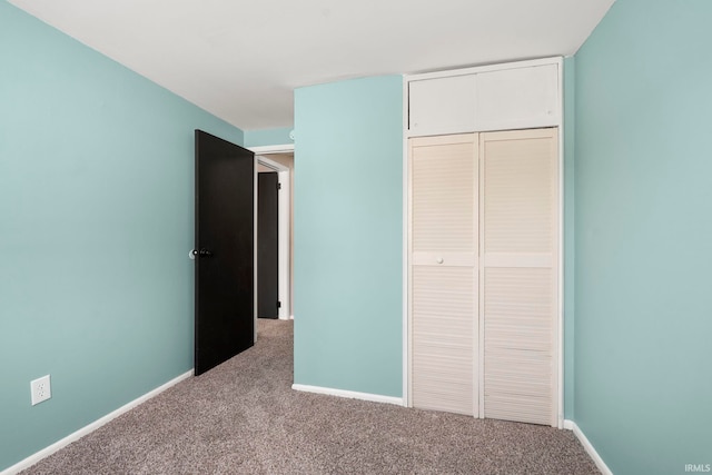 unfurnished bedroom featuring a closet, carpet flooring, and baseboards