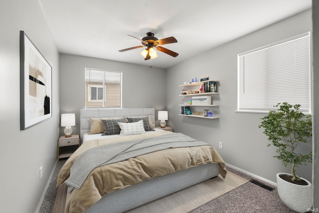 carpeted bedroom featuring a ceiling fan, visible vents, and baseboards