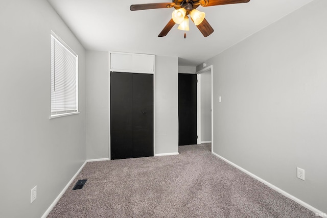 unfurnished bedroom featuring ceiling fan, carpet, visible vents, and baseboards