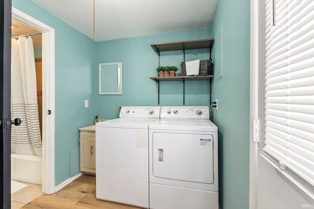 laundry area featuring laundry area, light wood finished floors, and washing machine and clothes dryer