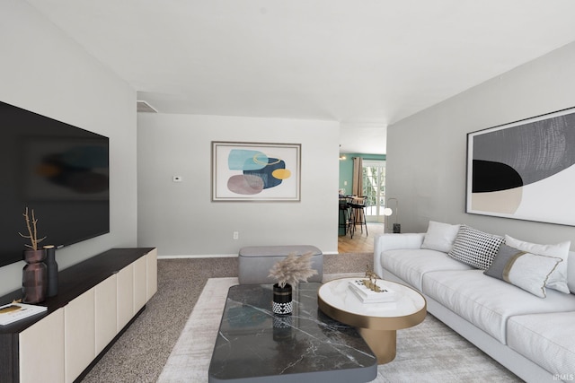 living area featuring baseboards and light colored carpet