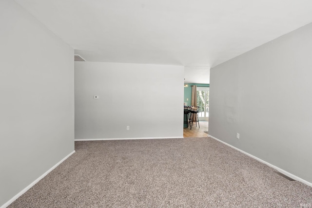 empty room with light colored carpet and baseboards