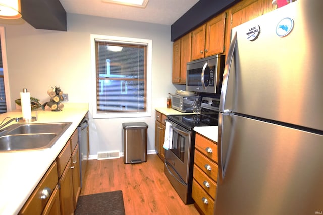 kitchen with stainless steel appliances, visible vents, light countertops, dark wood-style floors, and brown cabinetry