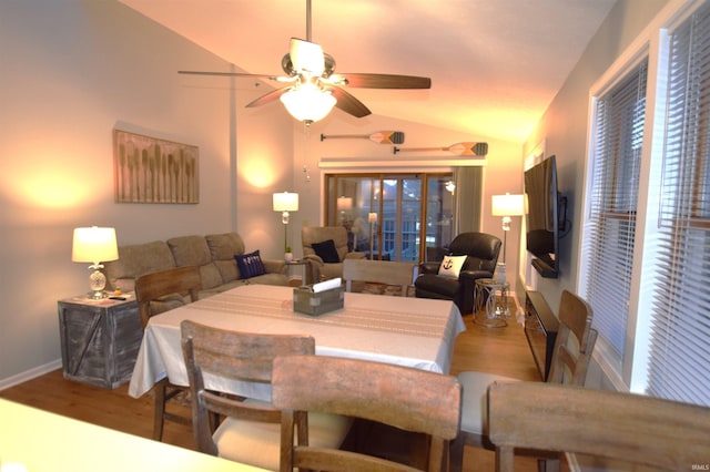 dining room featuring vaulted ceiling, wood finished floors, a ceiling fan, and baseboards