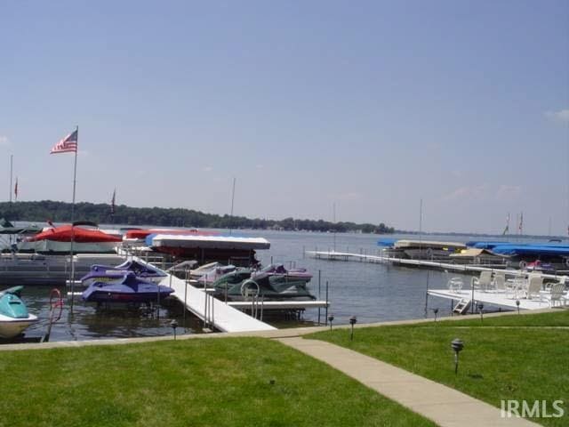 dock area with a water view and a yard