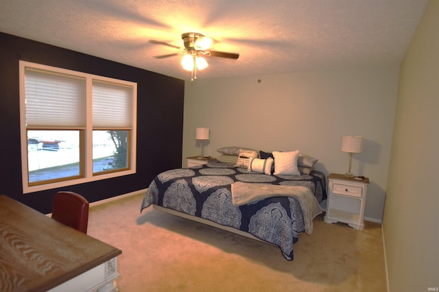 bedroom featuring carpet floors, a ceiling fan, baseboards, and a textured ceiling