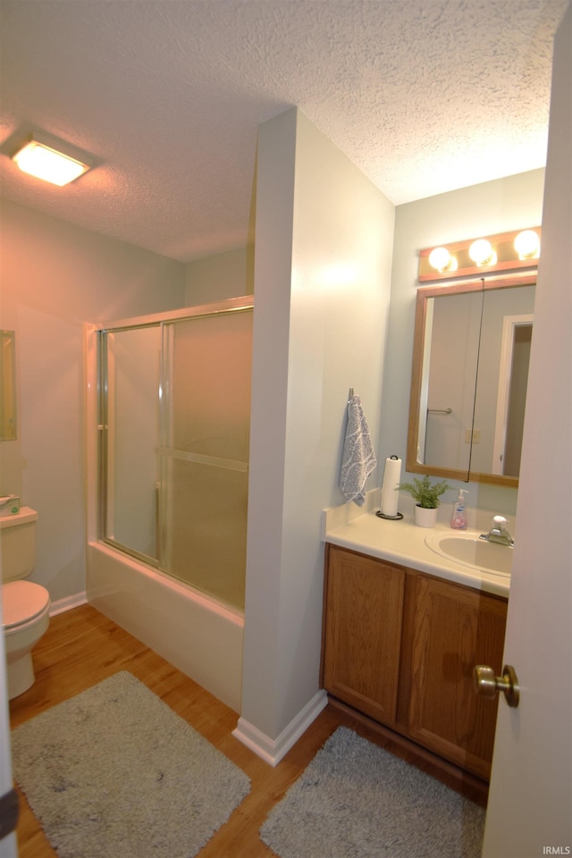 bathroom with a textured ceiling, vanity, wood finished floors, and toilet