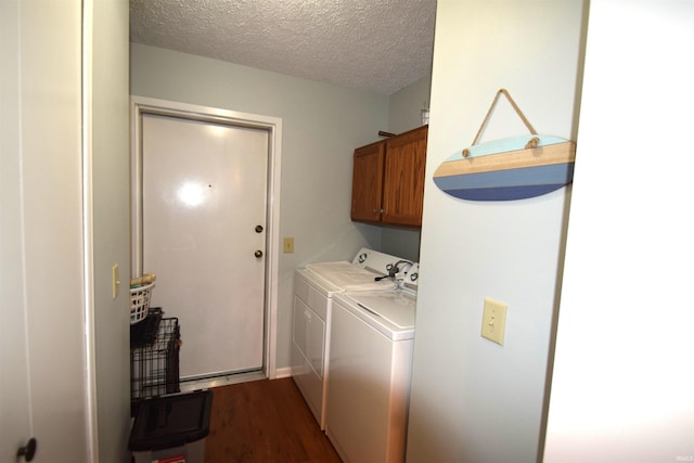 laundry area with dark wood-style floors, cabinet space, washer and clothes dryer, and a textured ceiling