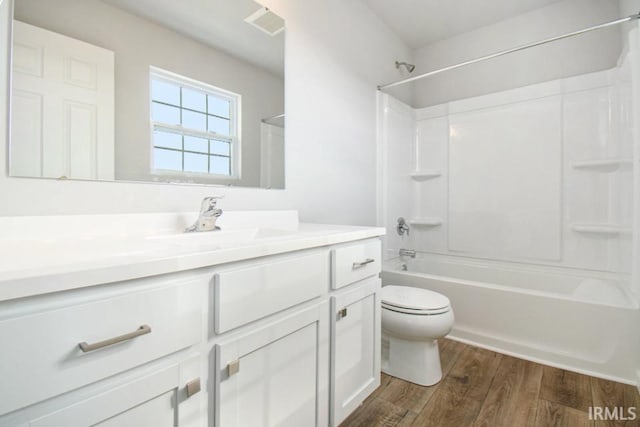 full bathroom featuring toilet, vanity, wood finished floors, and shower / bathtub combination