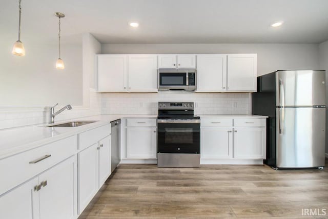 kitchen featuring stainless steel appliances, backsplash, and white cabinetry