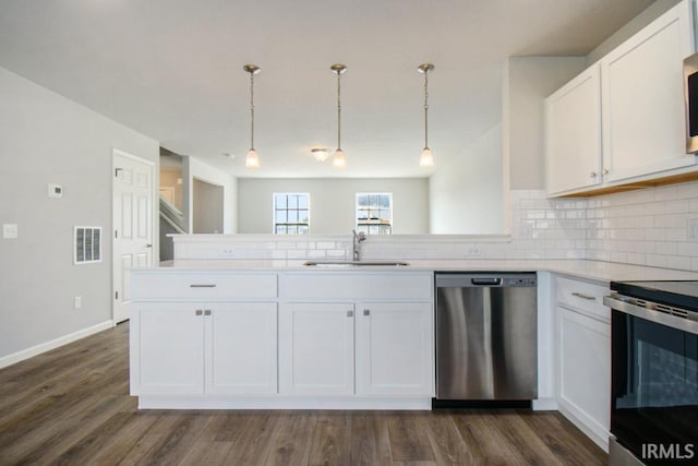 kitchen featuring decorative backsplash, appliances with stainless steel finishes, white cabinets, and a sink