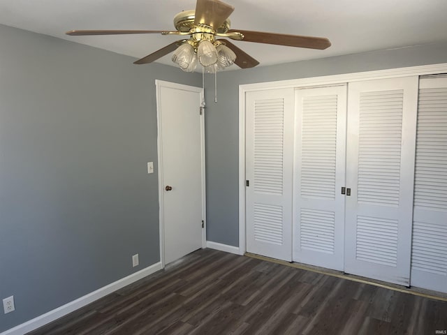 unfurnished bedroom featuring dark wood-style floors, a ceiling fan, baseboards, and a closet