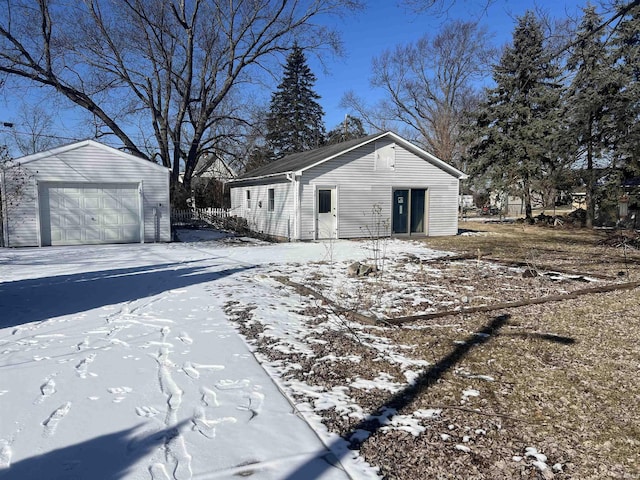 exterior space with driveway, an outdoor structure, and a detached garage