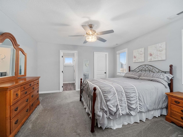 carpeted bedroom featuring a ceiling fan, visible vents, a textured ceiling, and baseboards