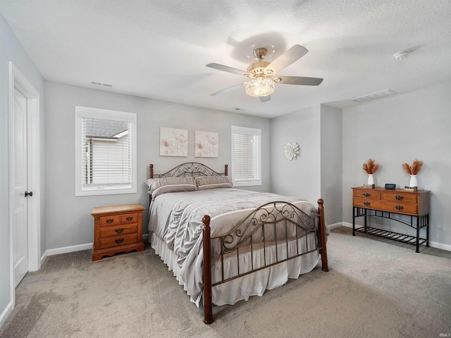 bedroom with baseboards, a textured ceiling, visible vents, and carpet flooring