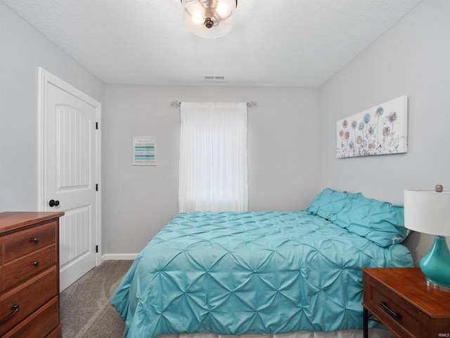 carpeted bedroom with baseboards, visible vents, and a textured ceiling