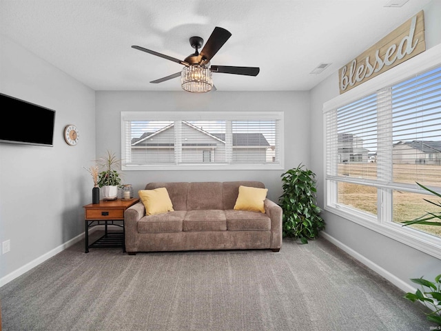 living area with carpet, visible vents, ceiling fan, and baseboards