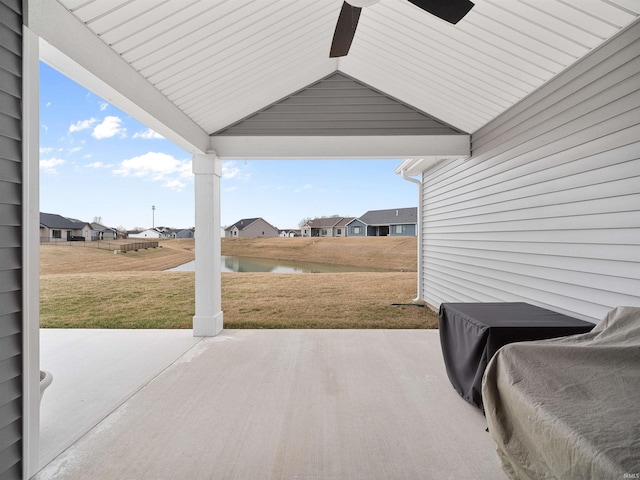 view of patio with a ceiling fan and a water view