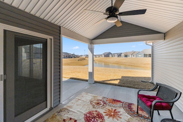 view of patio with a water view and a ceiling fan