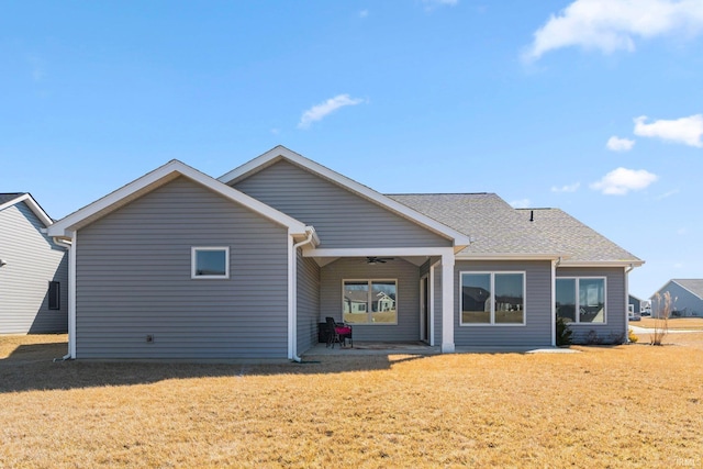 back of house with a ceiling fan and a yard