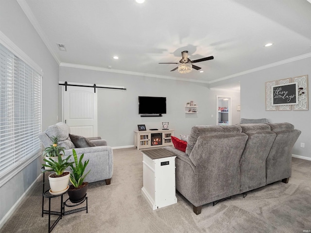 living area with light colored carpet, visible vents, a barn door, a ceiling fan, and baseboards