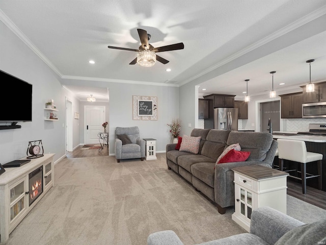 living area with baseboards, light colored carpet, ceiling fan, crown molding, and recessed lighting