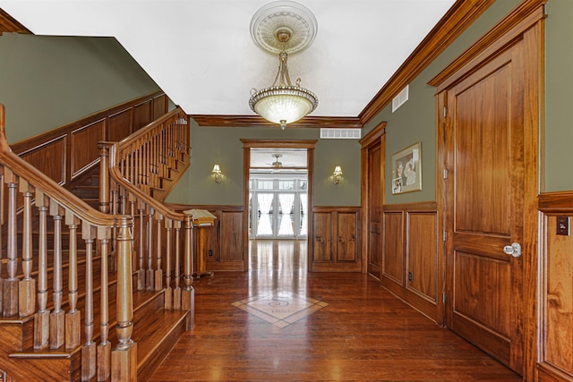 foyer featuring stairs, wainscoting, visible vents, and wood finished floors