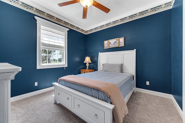 carpeted bedroom with a ceiling fan, baseboards, and crown molding