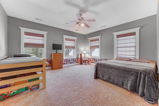 bedroom with a ceiling fan, carpet, and visible vents