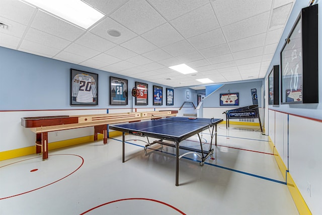 recreation room with concrete flooring, visible vents, a paneled ceiling, and baseboards