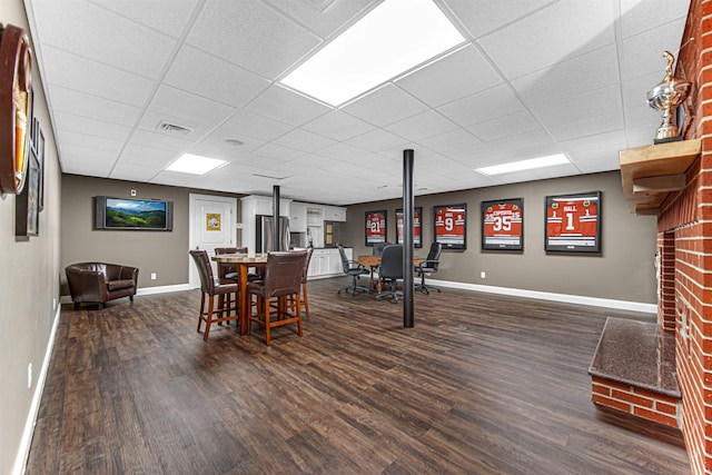 dining room with dark wood finished floors, visible vents, and baseboards