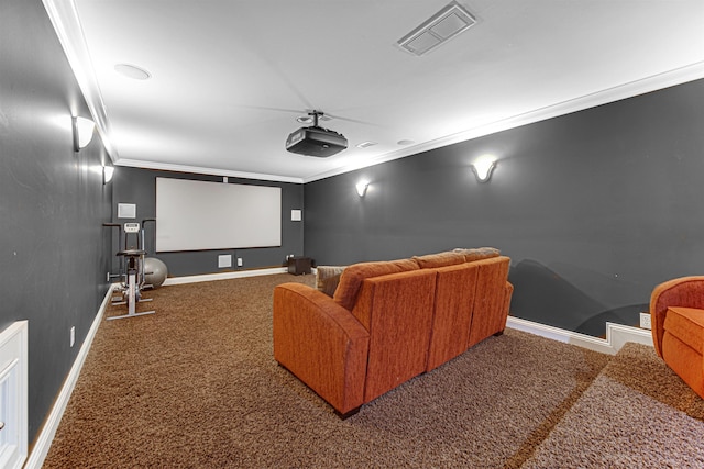 cinema room with carpet floors, visible vents, crown molding, and baseboards