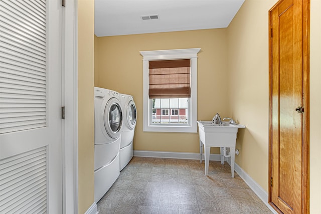 laundry area with washing machine and dryer, laundry area, visible vents, and baseboards