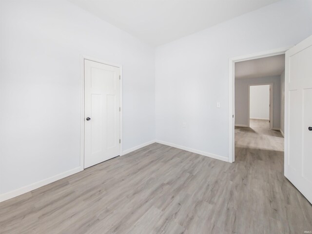 unfurnished room featuring light wood-style flooring and baseboards