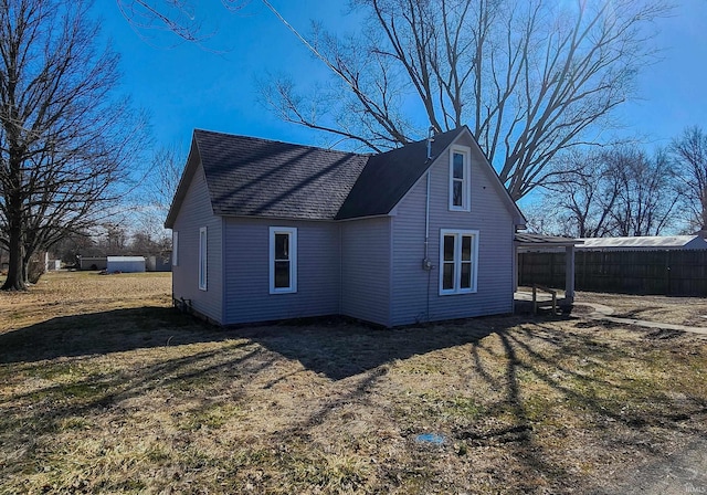 rear view of property featuring a shingled roof