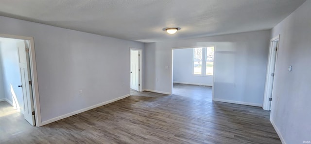 spare room with wood finished floors and baseboards