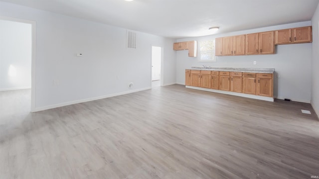 kitchen featuring light countertops, light wood-style flooring, visible vents, and baseboards