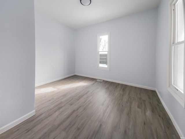 empty room featuring baseboards and wood finished floors