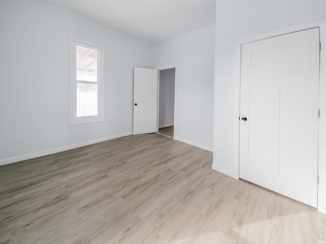 unfurnished bedroom with light wood-style flooring and baseboards