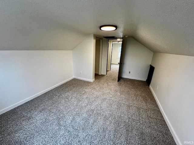 bonus room featuring carpet floors, baseboards, vaulted ceiling, and a textured ceiling