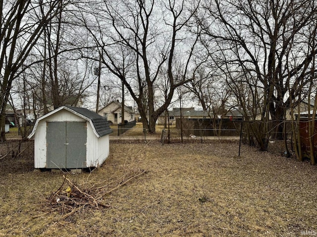 view of yard featuring fence, an outdoor structure, and a shed