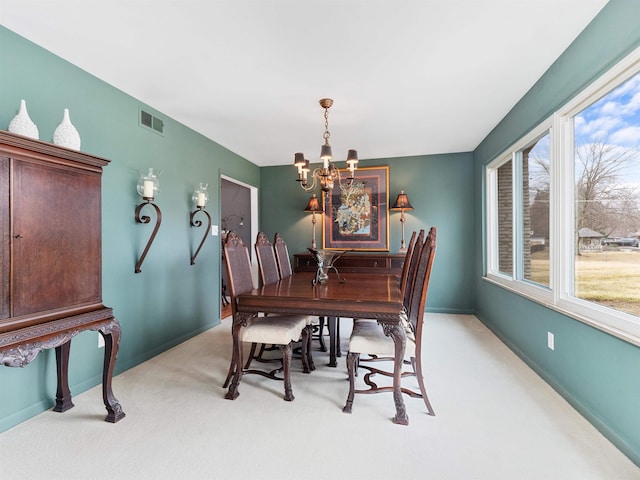 dining area featuring light colored carpet, visible vents, baseboards, and an inviting chandelier