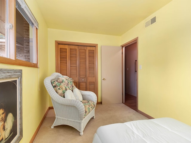 carpeted bedroom featuring a closet, visible vents, and baseboards