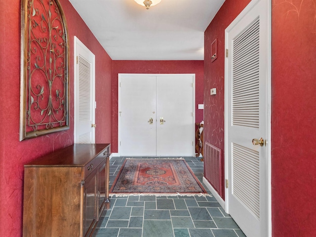 entrance foyer featuring stone finish floor and visible vents